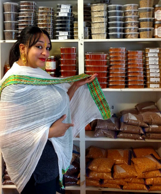 Picture of store owner with spices.